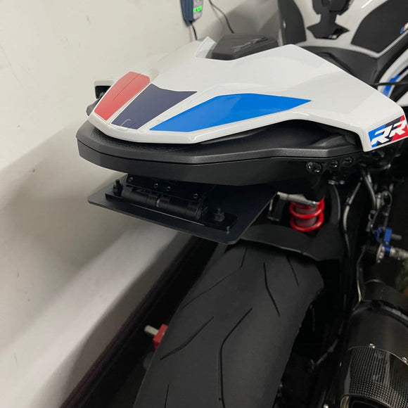 Close-up of a motorcycle with a colorful seat cover against a white background